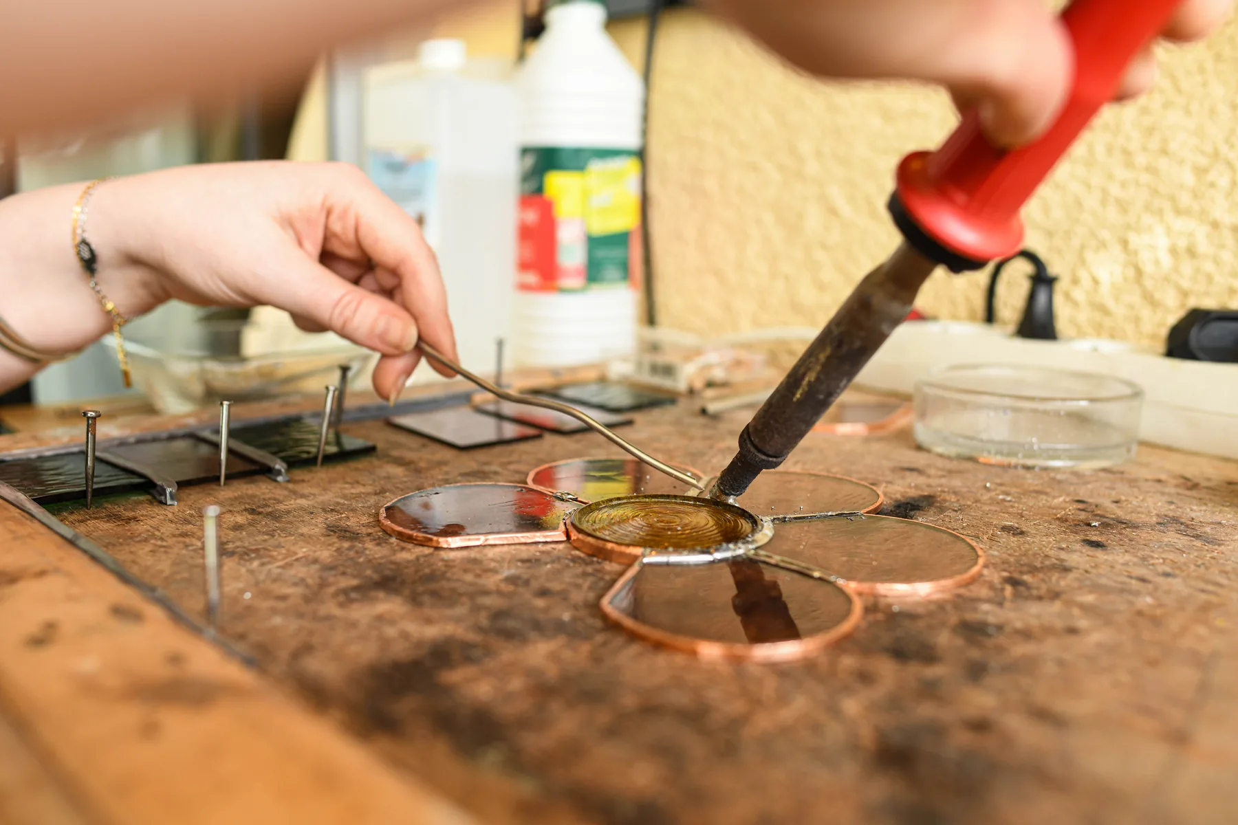 La soudure réunit les morceaux de verre sertis de cuivre.